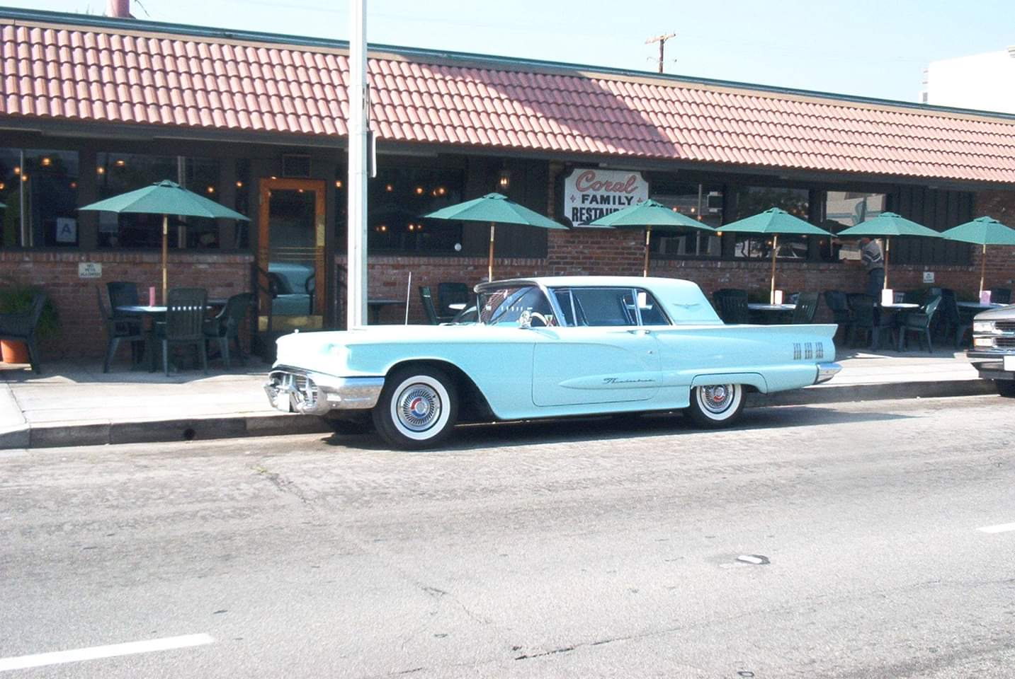 A vintage Thunderbird parked out front of the Coral Cafe